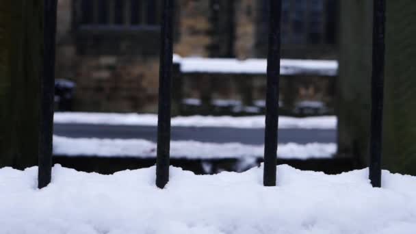 Zábradlí pokryté sněhem s kostelem budovy v pozadí — Stock video