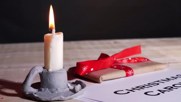 Christmas carol song sheet with candle and gift — Stock Video