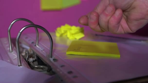 Businessman organizing work using sticky notes on files and folders