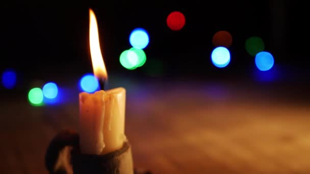 Vintage style candle burns with Christmas lights bokeh background — 图库视频影像