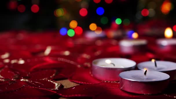 Velas Tealight sobre fondo rojo con luces navideñas — Vídeos de Stock