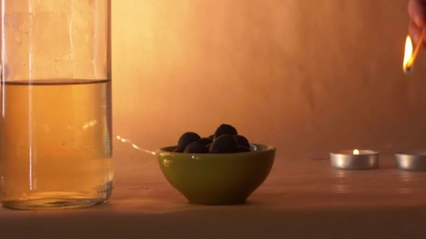 Iluminando uma vela com garrafa de vinho e azeitonas — Vídeo de Stock