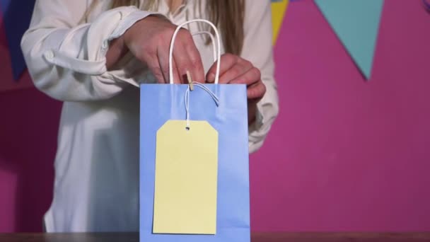 Κορίτσι γενεθλίων ψάχνει για δώρο σε πολύχρωμη τσάντα — Αρχείο Βίντεο