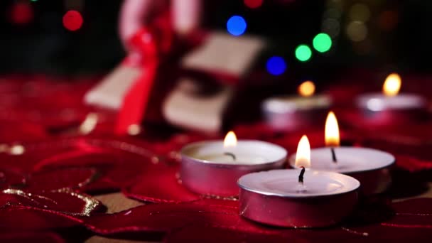 Tealight candles at Christmas with bokeh lights and gift — Stockvideo