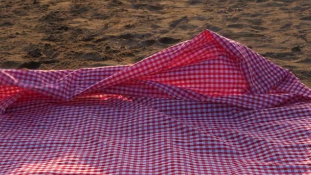 Paño de picnic rojo en la playa arena — Vídeos de Stock