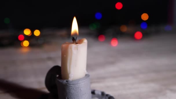 Vintage style candle burns with Christmas lights bokeh background — 图库视频影像