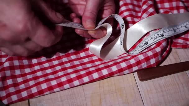 Руки портного с тканями и рулеткой для шитья — стоковое видео