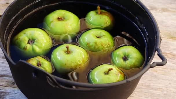 Frische Äpfel im Hexenkessel zum Wippen an Halloween — Stockvideo