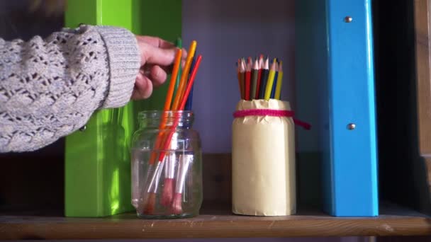 Artist choosing from selection of paintbrushes — Vídeo de stock