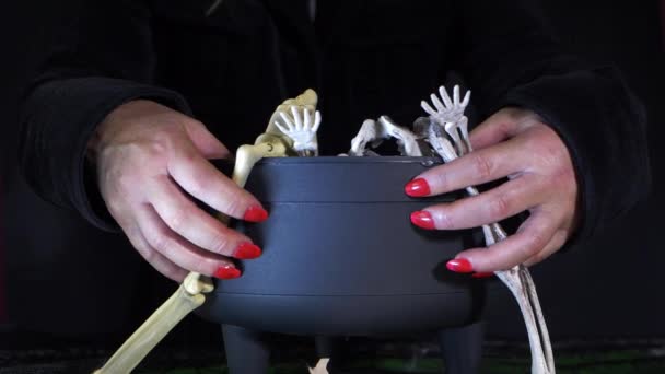 Evil witch with her cauldron on dark background — стоковое видео