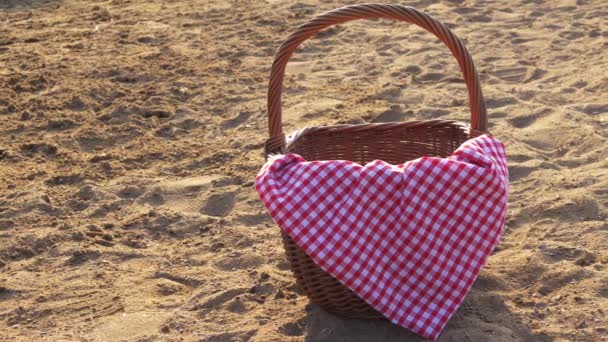 Cesta de picnic con tela de jengibre roja en la arena de playa — Vídeos de Stock