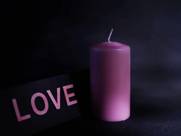 Romantyczna różowa świeca na czarnym tle średnim ujęciu — Zdjęcie stockowe