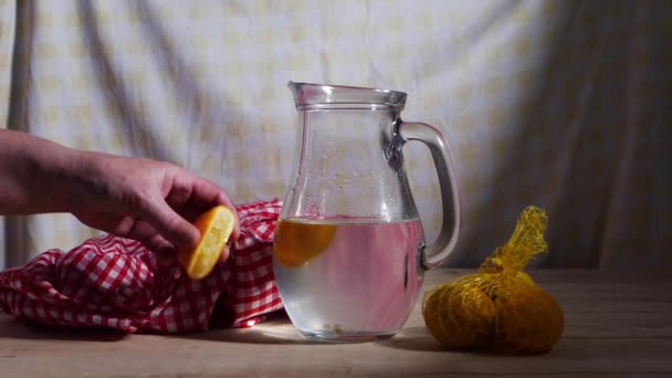 Krama färsk citronsaft i en kanna vatten — Stockvideo