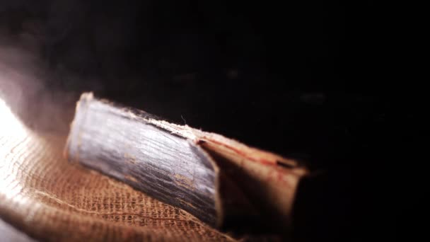 Παλιό φθαρμένο βιβλίο σε σάκο και σκούρο φόντο καπνού — Αρχείο Βίντεο