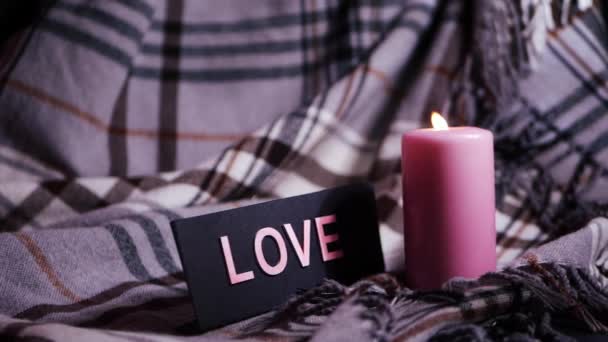 Romantic pink candle on cozy blanket background — Stock Video