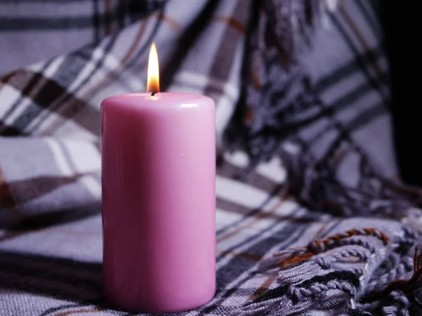 Romantische roze kaars op gezellige deken achtergrond — Stockfoto