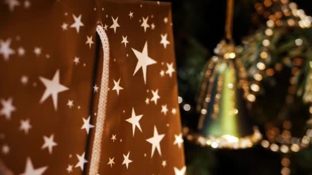 Zabalený vánoční dárek s ozdobným šumivým zvonek dekorace bokeh — Stock video
