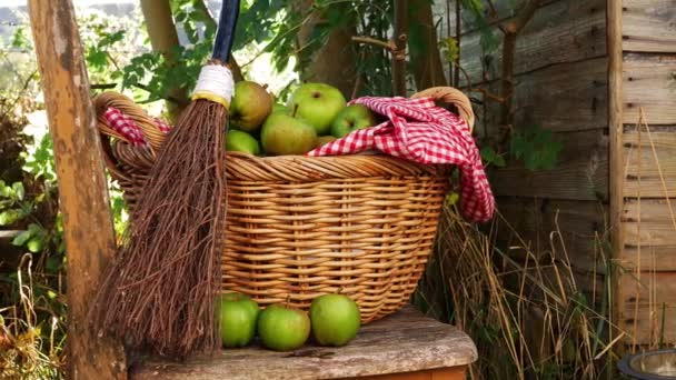 Basket of fresh baking apples with broomstick for Halloween in countryside scene — Stock Video