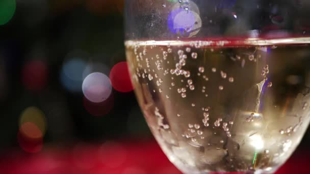 Copa de vino blanco sobre mesa con fondo de luces bokeh — Vídeos de Stock
