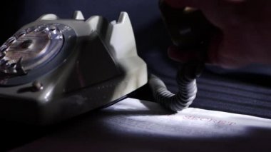 Eskimiş telefonlu karanlık odada çok gizli bir belge.