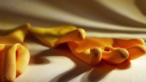 Желтые резиновые чистящие перчатки на желтом фоне — стоковое видео