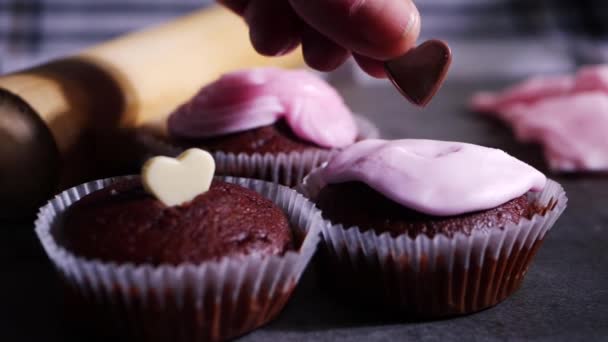 Schokoladen-Cupcakes mit Schokolade-Liebesherz dekorieren — Stockvideo