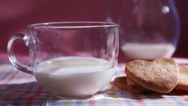 Kézzel ragadja meg a frissen sült sütit egy pohár tejjel. — Stock videók
