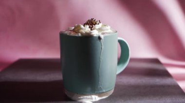 Çikolata parçacıkları pembe arka planda sıcak çikolata içeceği.