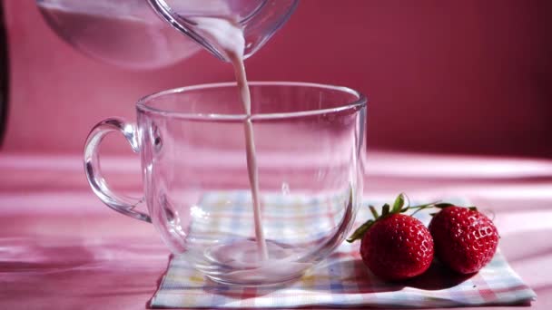 Häll jordgubbsmjölkshake på rosa bakgrund — Stockvideo