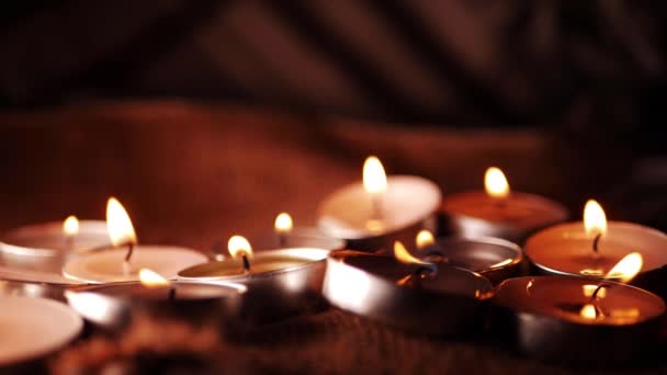 Teelichterkerzen zur Meditation auf warmem Hintergrund arrangiert — Stockvideo