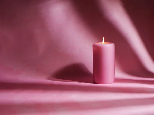 Романтична рожева свічка на рожевому фоні середній постріл — стокове фото