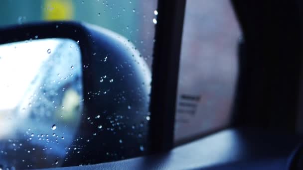 Driving through urban area in the rain through view of rear view mirror — Stock Video