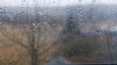 Kırsal manzaranın pencere görünümünde yağmur damlalarının zaman aşımı seçici odak noktasını kapat