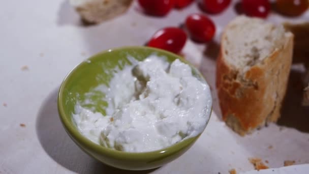 Bowl of cottage cheese curds and whey with bread and tomatoes — Stock Video