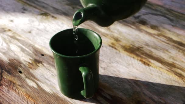 Verter una taza de té sobre un fondo rústico — Vídeos de Stock