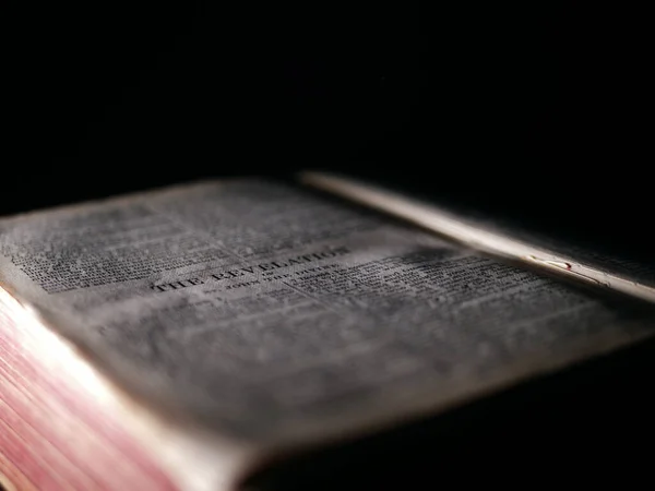 Livro de revelações na Bíblia Sagrada sobre fundo escuro — Fotografia de Stock