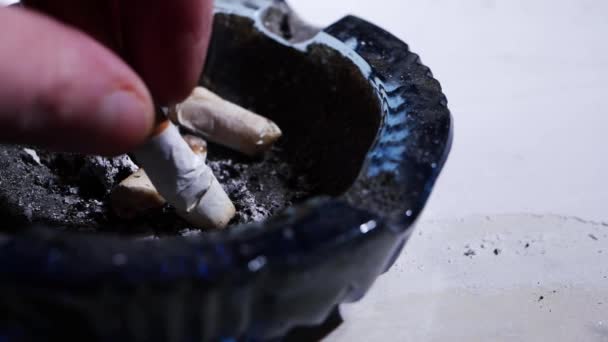 Бросать сигарету в грязную пепельницу — стоковое видео