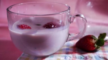 Pembe arka planda çilekli milkshake. 