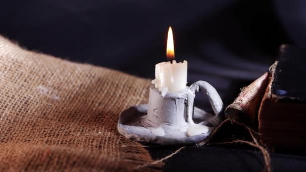 Starověká opotřebovaná kniha a svíčka na Hesenském pytli — Stock video