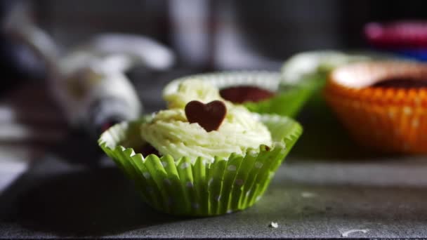 Cupcake decorated with frosting and chocolate love heart — Stock Video