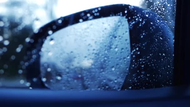 Driving through urban area in the rain through view of rear view mirror — Stock Video