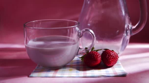 Copo de milkshake de morango no fundo rosa — Vídeo de Stock