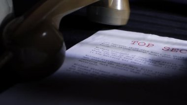 Eskimiş telefonlu karanlık odada çok gizli bir belge.