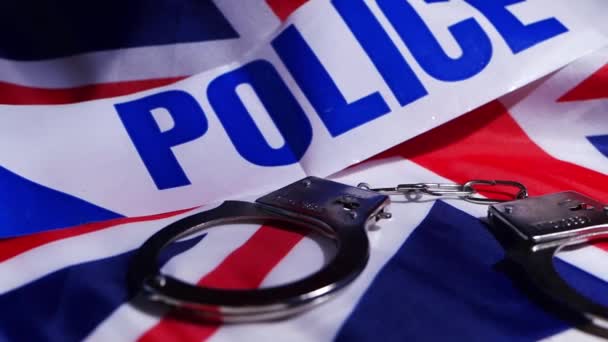 Концепція британських поліцейських сил з наручниками і союзним джеком — стокове відео