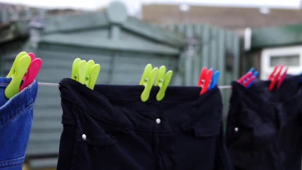 Roupas pendurar na linha de lavagem no dia ventoso — Vídeo de Stock