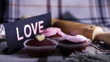 Kremayla süslenmiş fırında çikolatalı kekler ve çikolatalı aşk kalpleri. 