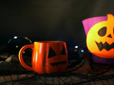 Cadılar Bayramı balkabağı içeceği, krema kaplı koyu arkaplan 