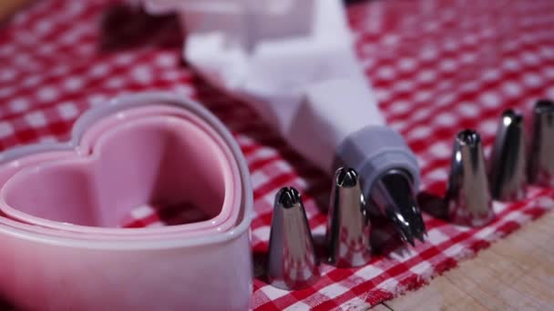 Kitchen table with piping bag and cookie cutter for homemade baking — Stock Video