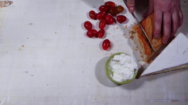 Slicing a baguette loaf with cheese and tomatoes — Stock Video
