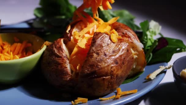 Bratkartoffeln mit geriebenem Käsebelag bestreuen — Stockvideo